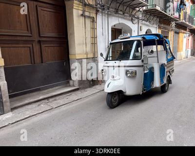Piaggio APE taxi / Apecar à Palerme, Sicile, Italie. Emblématique véhicule italien à trois roues naviguant dans une rue étroite et traditionnelle. Banque D'Images
