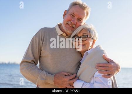 Couple senior mature embrassant profitant des loisirs en plein air marchant sur la plage. Vieux mari épouse embrassant avec tendresse amour profiter Banque D'Images