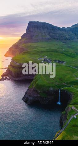 Coucher de soleil à couper le souffle sur le village de Gasadalur et la cascade Mulafossur dans les îles Féroé Banque D'Images