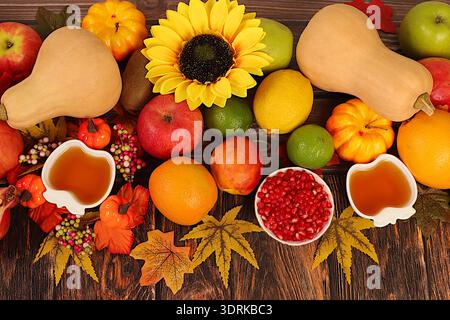 Bannière de Thanksgiving, fond d'automne avec des pommes, grenades, citrouilles, miel, raisins, fleurs sous tournesols et feuilles o Banque D'Images
