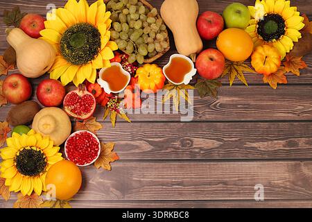 Concept de récolte, bannière de Thanksgiving, fond d'automne avec des pommes, grenades, citrouilles, miel, raisins, fleurs sous sunflo Banque D'Images