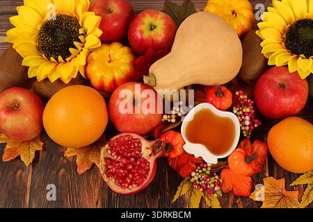 Bannière de Thanksgiving, fond d'automne avec des pommes, grenades, citrouilles, miel, raisins, fleurs sous tournesols et feuilles o Banque D'Images