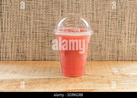un smoothie aux baies rouges épais et éclatant où le rouge framboise et le violet myrtille se mélangent dans un dégradé parfait dans un grand verre. Banque D'Images