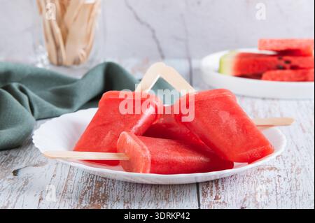 Pastèque popsicles sur des bâtons de bois sur une assiette sur une table Banque D'Images