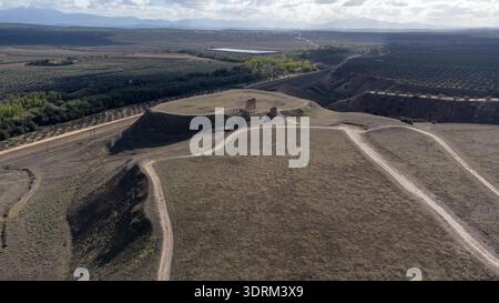 Drone aérien montrant un plateau avec des ruines de tour et la campagne environnante sur le site archéologique de Cástulo près de Linares, Jaén, Andalousie, Espagne. Banque D'Images