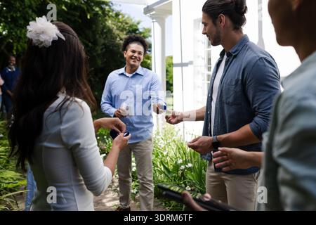 Les invités échangent des cadeaux colorés à l'extérieur, souriant et profitant de la célébration de mariage. festivités, cadeaux, joyeux, bonheur, c Banque D'Images