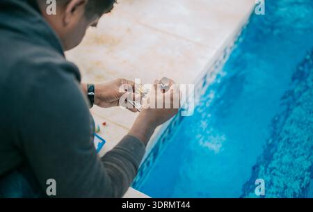 Kit testeur pour mesurer le chlore et le ph dans les piscines. Personne testant le pH de la piscine Banque D'Images