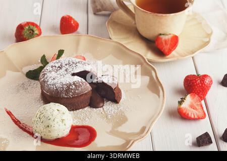 Fondant au chocolat avec glace à la vanille et fraise Banque D'Images