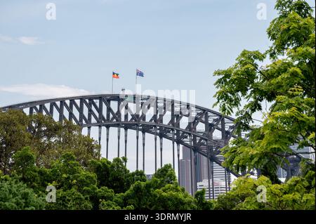 Le drapeau national australien et le drapeau aborigène flottent au sommet du pont de la baie de Sydney. Banque D'Images