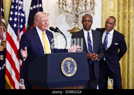 Le président des États-Unis Donald Trump prend la parole lors d'une réception pour le mois de l'histoire des Noirs dans la salle est de la Maison Blanche à Washington, DC, États-Unis, le 18 février 2026. L’événement survient moins de deux semaines après que le compte Truth social du président Trump a partagé une vidéo raciste de l’ancien président Barack Obama et de l’ancienne première dame Michelle Obama. Regardant de droite à droite, l'ancien secrétaire américain au logement et au développement urbain (HUD) Dr Ben Carson, au centre, et le secrétaire américain au logement et au développement urbain Scott Turner. Crédit : Jim LoScalzo / piscine via CNP Banque D'Images