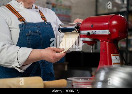 Gros plan du chef utilisant la machine à pâtes dans la cuisine. Banque D'Images