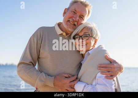 Couple senior mature embrassant profitant des loisirs en plein air marchant sur la plage. Vieux mari épouse embrassant avec tendresse amour profiter Banque D'Images