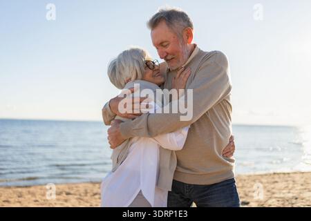 Couple senior mature embrassant profitant des loisirs en plein air marchant sur la plage. Vieux mari épouse embrassant avec tendresse amour profiter Banque D'Images