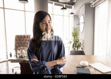 Joyeuse jeune femme professionnelle asiatique posant pour un portrait franc Banque D'Images