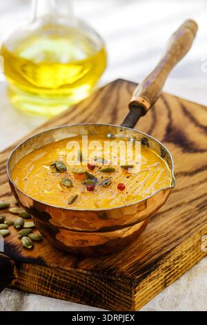 Purée de carottes et de potiron soupe avec des graines, du poivre rose et d'huile d'olive. Le déjeuner savoureux et sain pour les gourmets Banque D'Images