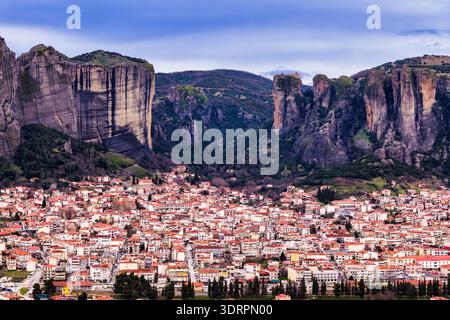 Kalambaka, Grèce. Photographie aérienne montrant les toits de tuiles rouges de la ville sous les imposants piliers rocheux des Météores, capturant le contraste entre u Banque D'Images