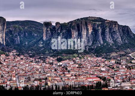 Kalambaka, Grèce. Photographie aérienne montrant les toits de tuiles rouges de la ville sous les imposants piliers rocheux des Météores, capturant le contraste entre u Banque D'Images