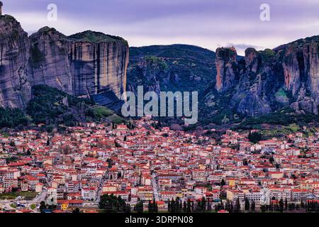 Kalambaka, Grèce. Photographie aérienne montrant les toits de tuiles rouges de la ville sous les imposants piliers rocheux des Météores, capturant le contraste entre u Banque D'Images