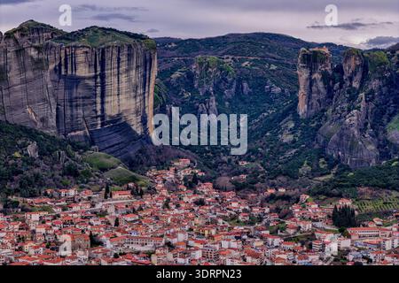 Kalambaka, Grèce. Photographie aérienne montrant les toits de tuiles rouges de la ville sous les imposants piliers rocheux des Météores, capturant le contraste entre u Banque D'Images