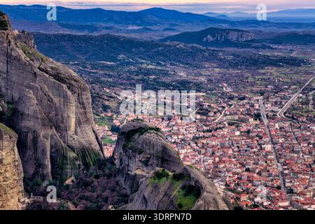 Kalambaka, Grèce. Photographie aérienne montrant les toits de tuiles rouges de la ville sous les imposants piliers rocheux des Météores, capturant le contraste entre u Banque D'Images