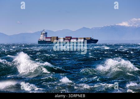 Une collection de photographies côtières spectaculaires montrant un cargo naviguant sur une mer agitée, de puissantes vagues s'écrasant contre une jetée en béton et un méta Banque D'Images