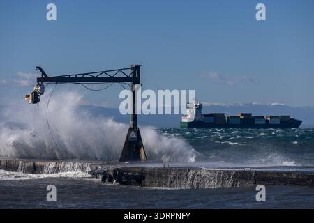 Une collection de photographies côtières spectaculaires montrant un cargo naviguant sur une mer agitée, de puissantes vagues s'écrasant contre une jetée en béton et un méta Banque D'Images