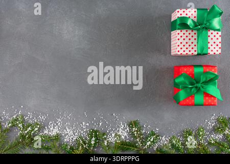 Collection cadeau sur une surface grise avec des décorations festives et une touche de neige Banque D'Images