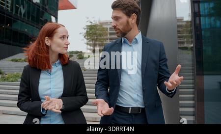 Femme d'affaires caucasienne partenaires parlant de projet marchant dans la ville d'âge moyen femme d'affaires adulte hommes d'affaires collègues formels Banque D'Images