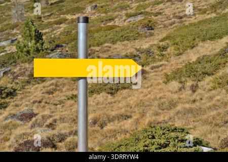 Flèche jaune vierge pointant vers la droite sur un sentier de montagne Banque D'Images