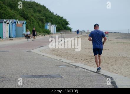 la vue arrière d'un homme dehors jogging le long du front de mer sur un jour d'été royaume-uni Banque D'Images