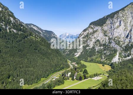 Vue aérienne d'une vallée verdoyante entourée de montagnes imposantes, où les ombres dansent avec la lumière du soleil, Wildalpen, Styrie, Autriche. Banque D'Images