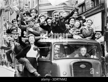 8 mai 1945. Un chargement de camions de personnes voyageant le long du Strand à Londres, célébrant la reddition inconditionnelle de l'Allemagne lors de la seconde Guerre mondiale, le jour de la VE. Banque D'Images