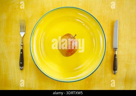 Régime et concept de réduction de poids, assiette avec couverts et une seule pomme Banque D'Images