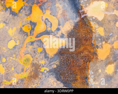 Vue aérienne de textures éclatantes ocre et grises se mêlent, révélant un paysage marqué par l'industrie et la touche de la nature, Plouasne, Bretagne, France. Banque D'Images