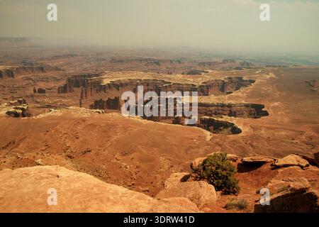 Formations de grès rouge désolées sous la brume. Vue sereine des pentes érodées du Canyon et des horizons lointains Banque D'Images