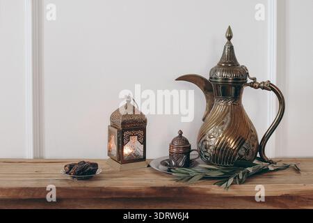 Élégant dîner iftar. Cafetière arabe, tasse de thé, dattes et lanterne sur plateau argenté. Branche d'olivier sur table en bois. Ramadan Kareem, vacances de l'Aïd Banque D'Images