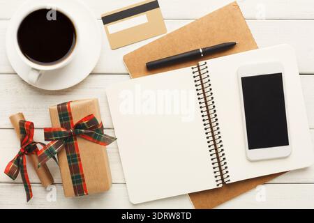 Collage d'éléments de l'espace de travail avec café, bloc-notes, stylo et boîte cadeau décorative sur la table en bois Banque D'Images