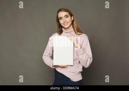 Collage d'un modèle tenant une toile vierge dans un simple réglage Studio Banque D'Images