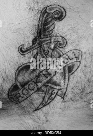 Gros plan d’un tatouage de cœur rock’n' roll fraîchement encré au Hemsby Rock’n' Roll Weekender à Norfolk, en Angleterre, célébrant la culture musicale vintage Banque D'Images