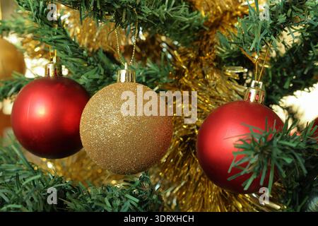 Ornements pour arbres de Noël. Couleurs dorées et rouges brillantes. Gros plan photo. Banque D'Images