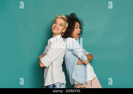 Deux femmes partagent un moment joyeux dans un ensemble de collage ludique sur un fond coloré Banque D'Images