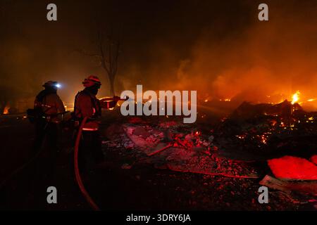 Un pompier utilise un tuyau d'eau pour combattre l'incendie de Dixie à Greenville, EN CALIFORNIE, le 4 août 2021. Banque D'Images