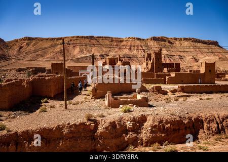 Une vue imprenable sur le ksar de Tamdaght (Tamddakhte), situé dans la vallée de l'Ounila près d'Aït Benhaddou. La photo capture un groupe de cavaliers passant Thr Banque D'Images