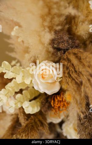 Une collection de fleurs et de plantes séchées montre différentes formes et couleurs. Ils sont disposés pour créer une pièce décorative. Ceci est vu dans un bien éclairé Banque D'Images