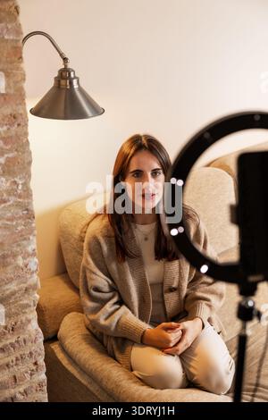 Femme créant du contenu de médias sociaux engageant avec la lumière annulaire Banque D'Images