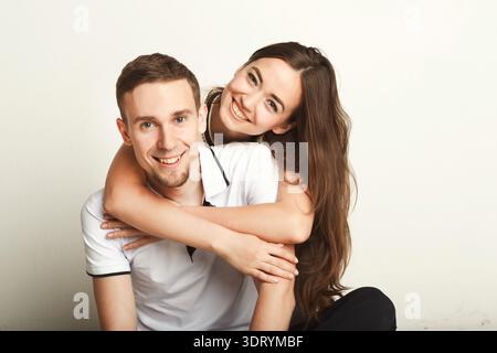 Un homme et une femme souriants s'embrassent sur un fond de plaine dans un joyeux moment de connexion Banque D'Images