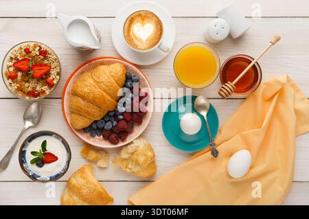 Collection petit déjeuner montrant divers aliments et boissons sur une table en bois Banque D'Images