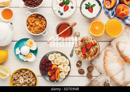 Collage coloré petit déjeuner avec divers aliments sur une table en bois pendant le matin Banque D'Images