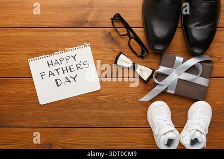 Cadeaux et cartes pour la fête des pères sur une table en bois avec différents articles et chaussures Banque D'Images