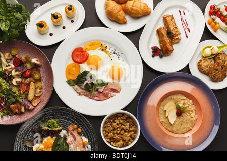 Délicieuse collection de plats de petit déjeuner servis sur des assiettes à une table à manger Banque D'Images